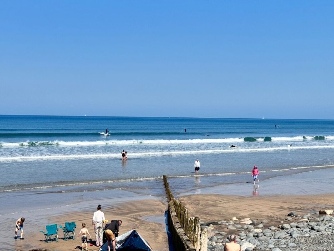 Golden sands of Westward Ho! beach with waves rolling in